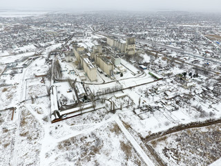 Sprinkled with snow grain elevator. Winter view of the old Soviet elevator. Winter view from the bird's eye view of the village. The streets are covered with snow