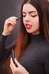 Make-up and cosmetics concept. Asian woman doing her makeup eyelashes dark mascara.