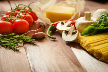 Pasta spaghetti with tomatoes, cheese and basil on rustic wooden background