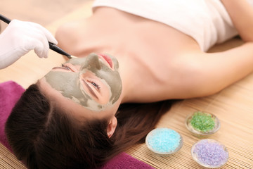 Obraz na płótnie Canvas Girl with facial mask lying in beauty health spa center