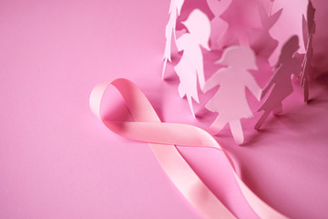 Obraz na płótnie Canvas The Sweet pink ribbon shape with girl paper doll on pink background for Breast Cancer Awareness symbol to promote in october month campaign