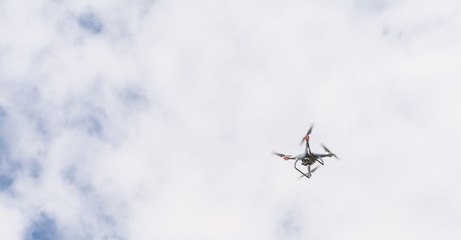 white drone hovering in a bright blue sky