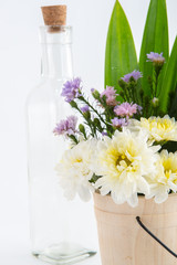 Colorful flowers in the wooden bucket on the white background