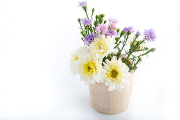 Colorful flowers in the wooden bucket on the white background