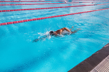 Swim sport swimmer man swimming in pool training for race. Professional male athlete exercising for...