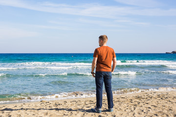 Young man relaxing on beach looking aside