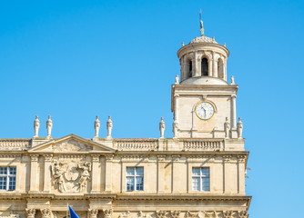 Fototapeta na wymiar Clock tower of museum at center square of Arles, France, under clear blue sky