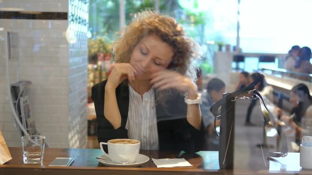 Young Beautiful Businesswoman With Coffee In Cafe Looking In Camera. 4K. 