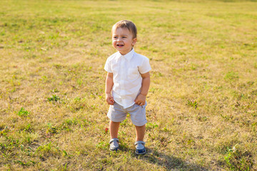 Happy laughing baby boy playing on summer or autumn nature.