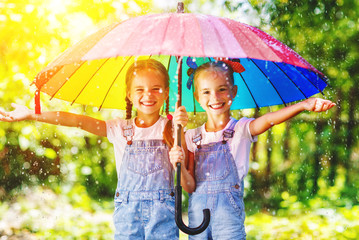 Happy funny sisters twins child girl with  umbrella