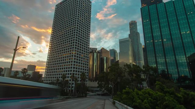 Cinematic 4K timelapse in motion or hyperlapse of downtown Los Angeles skyscrapers and city skyline at sunrise with fast moving clouds above.