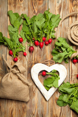 Fresh vegetables, radish, bag and heart on a wooden table
