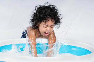 infant splashing water in bath tub, timely splash, hispanic boy