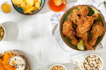 Frame of fried chicken, sauces, chips, peanuts, pistachios and crackers
