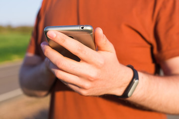 Close-up of Male runner jogging outside looking at his wearable fitness tracker outside.