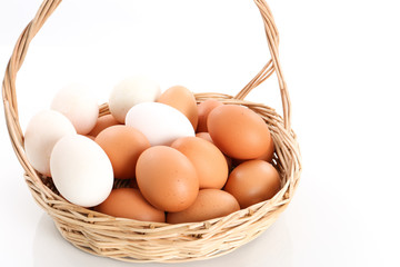 Eggs in a wooden basket on white background - close up