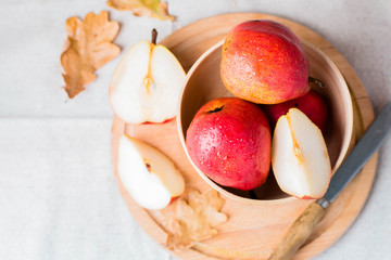 Top view of Fresh organic pears in wooden bowl on board on wooden table background. Healthy vegetarian food content. Autumn harvest