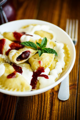 Homemade sweet dumplings with berries and sour cream