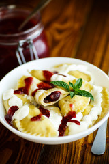 Homemade sweet dumplings with berries and sour cream