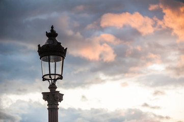 Fototapeta na wymiar Parisian lamppost against clouds at sunset, France