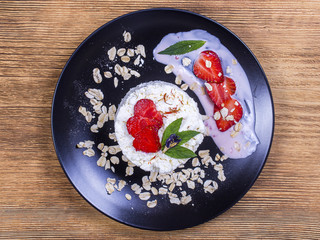 Cottage cheese, red strawberry and oat flakes on the table