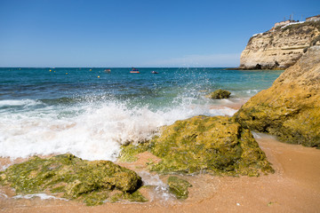 Waves crashing onto rocks at Carvoeiro beach in Portugal