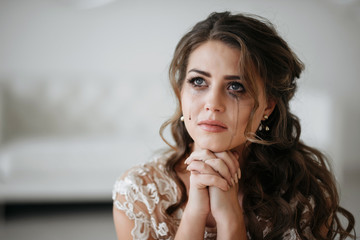 portrait of the bride crying, sadness, streaks mascara wipes. Natural light