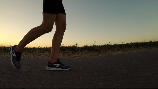 Exercise at sunset.
Young woman in evening fitness run - closeup of foot. Slow motion.