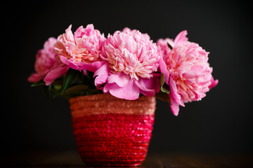 bouquet of pink peonies in a wicker vase