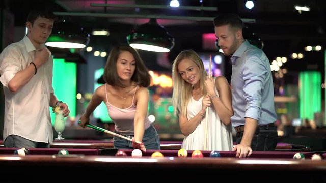 friends playing billiard together
