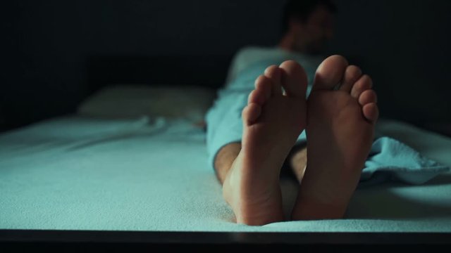 Man getting up from bed in morning, adult male waking up alone in bedroom