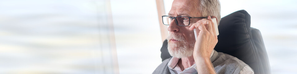 Portrait of bearded senior businessman talking on mobile phone