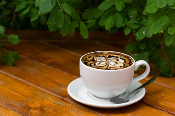 Coffee cup of cappuccino. Hot Cappuccino coffee with zigzag caramel on wooden background.