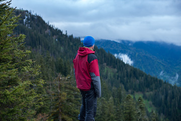 Traveler watching the movement of heavy clouds over the mountains