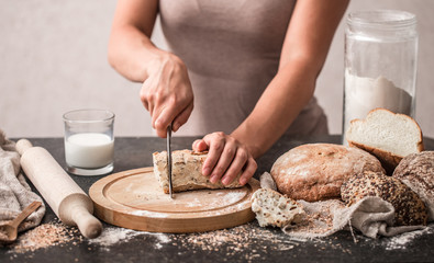 fresh bread in hands closeup on old wooden background