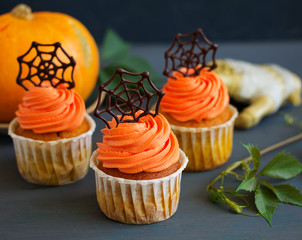 Pumpkin orange cupcakes for Halloween with chocolate cobweb.