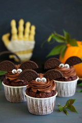 Chocolate muffins, with a chocolate cream in the form of bat on Halloween.