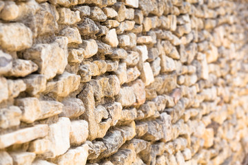 Wall of Field Stones / Closeup ancient natural wall of bright dry stones (focused and blurred part, copy space)