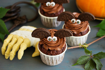 Chocolate muffins, with a chocolate cream in the form of bat on Halloween.