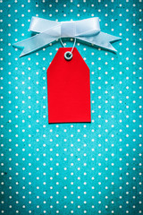 Cardboard sale tag on blue polka-dot table cloth
