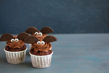 Chocolate muffins, with a chocolate cream in the form of bat on Halloween.