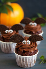 Chocolate muffins, with a chocolate cream in the form of bat on Halloween.