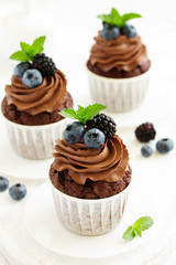 Chocolate cupcakes, with chocolate cream and fresh berries.