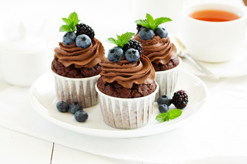Chocolate cupcakes, with chocolate cream and fresh berries.