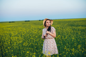 Fototapeta premium Beautiful young woman at sunset in the field