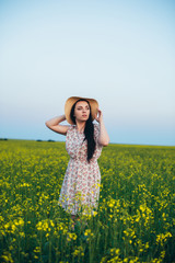 Fototapeta premium Beautiful young woman at sunset in the field