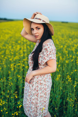 Naklejka na ściany i meble Beautiful young woman at sunset in the field