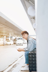 Young asian passenger waiting for taxi at the airport