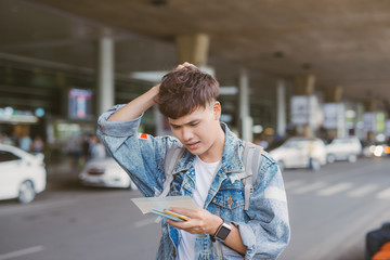 Handsome young man hold his head in hand and looking at his watche