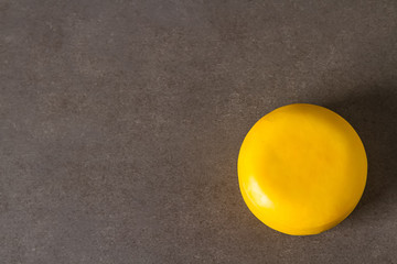 Round gouda cheese. Dark background.